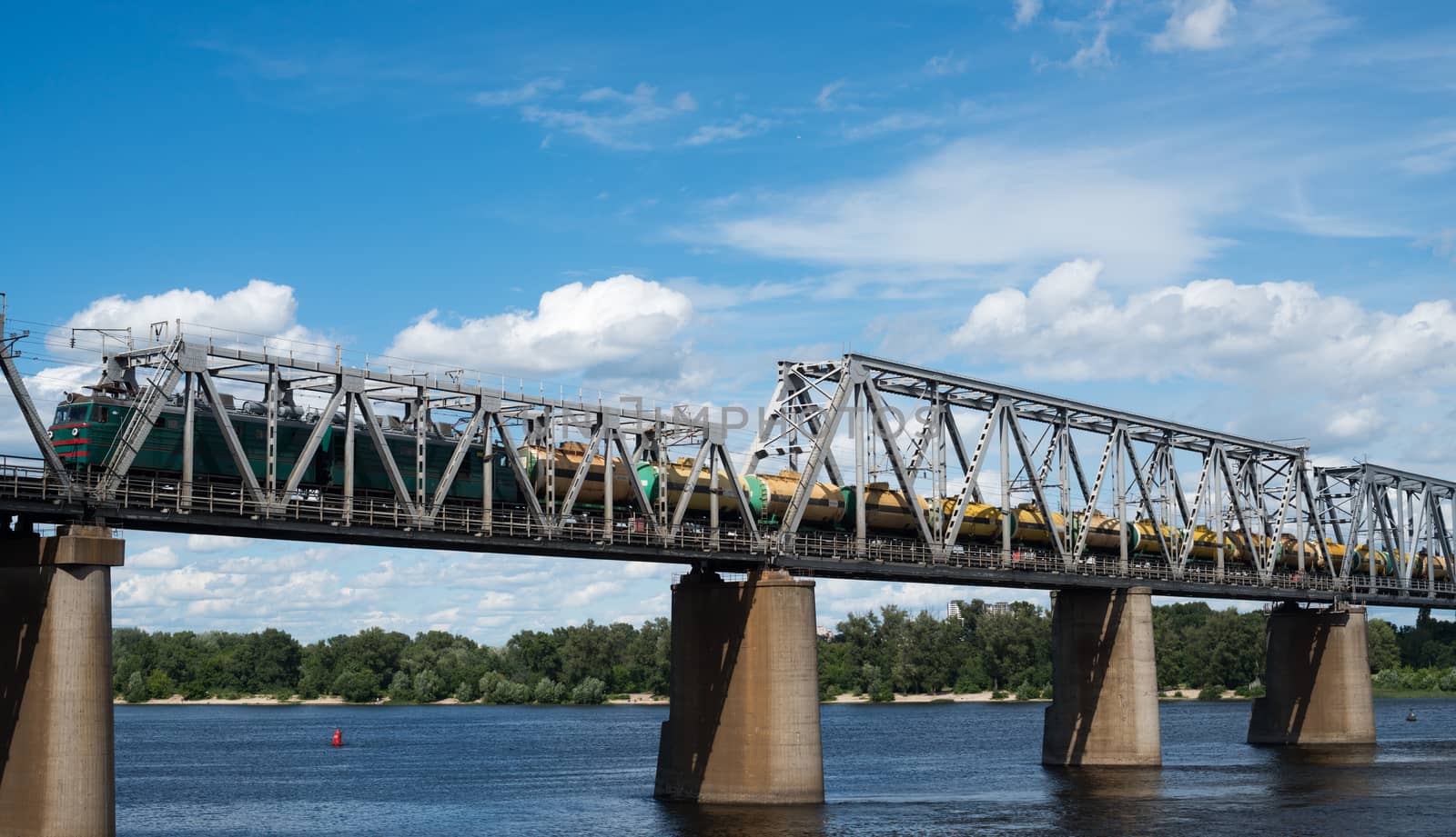 Petrivskiy railroad bridge in Kyiv across the Dnieper with freight train on it.