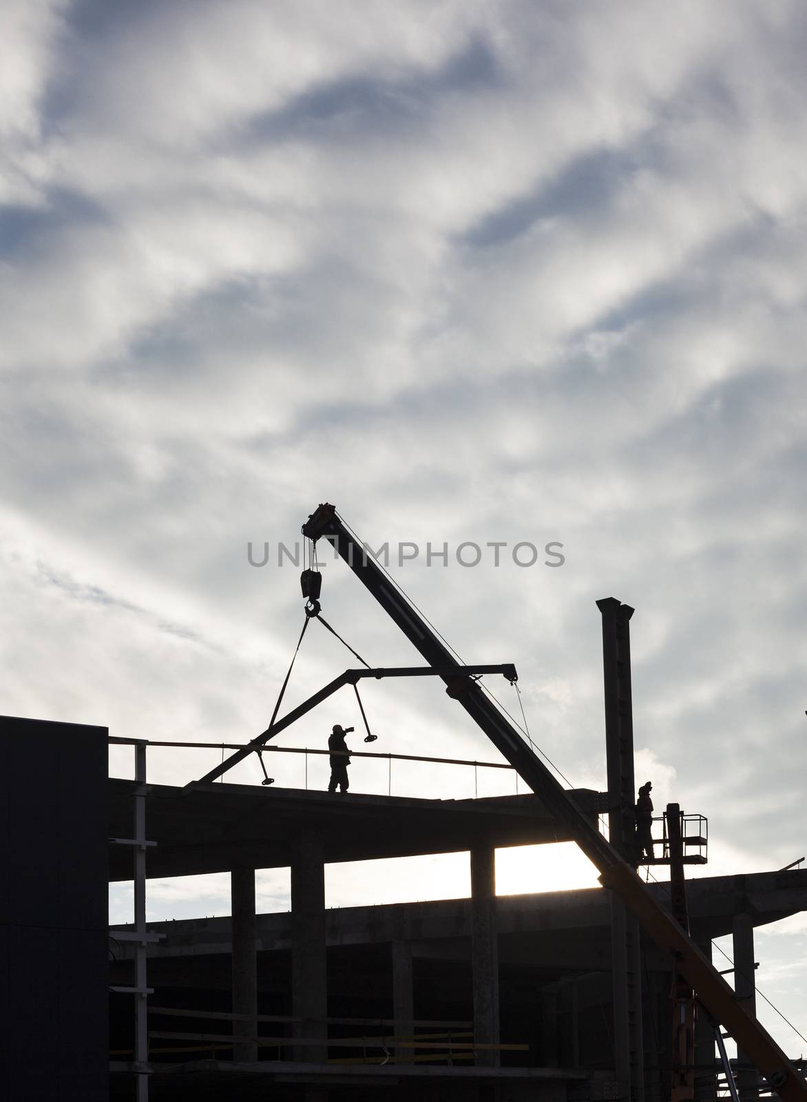 Construction of the new building. The crane working. Silhouette.