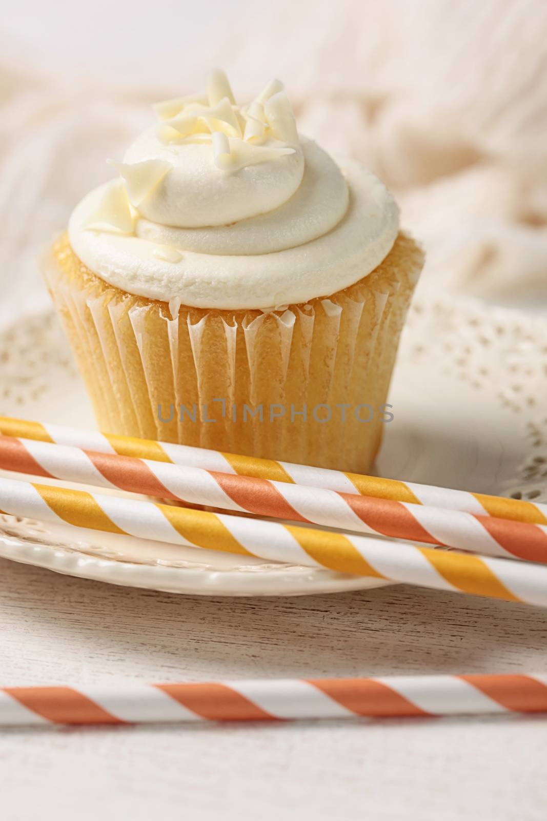Closeup of vanilla cupcake with orange straws