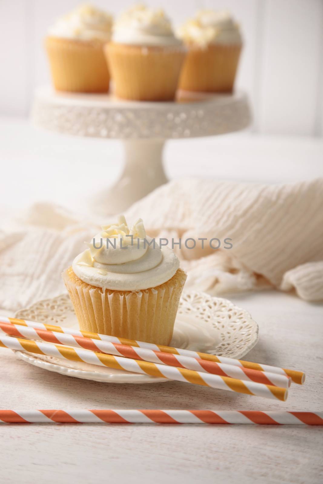 Sweet vanilla cupcake with orange straws