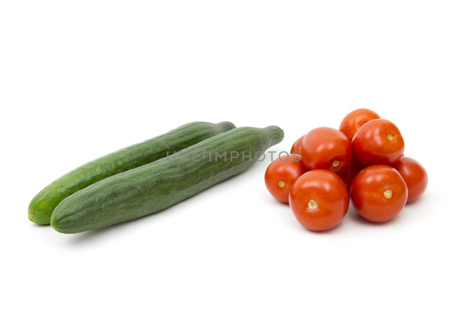fresh vegetables - tomatoes and cucumbers on white background