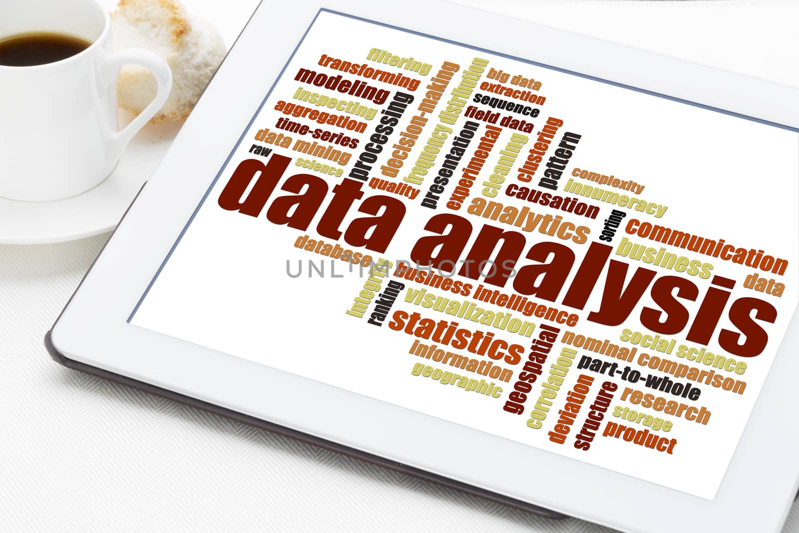 data analysis word cloud on a digital tablet with a cup of coffee