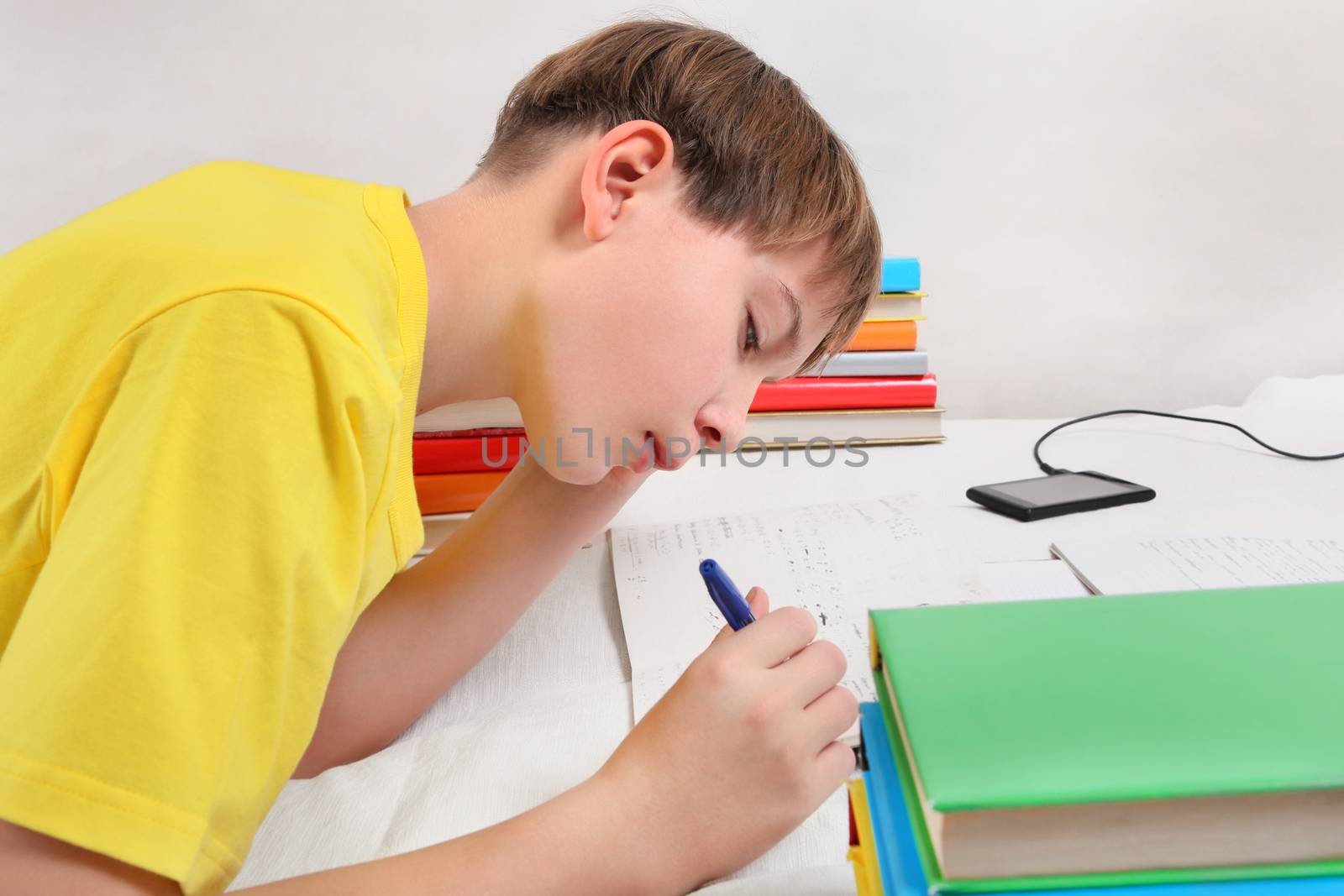 Kid doing Homework on the Sofa at the Home