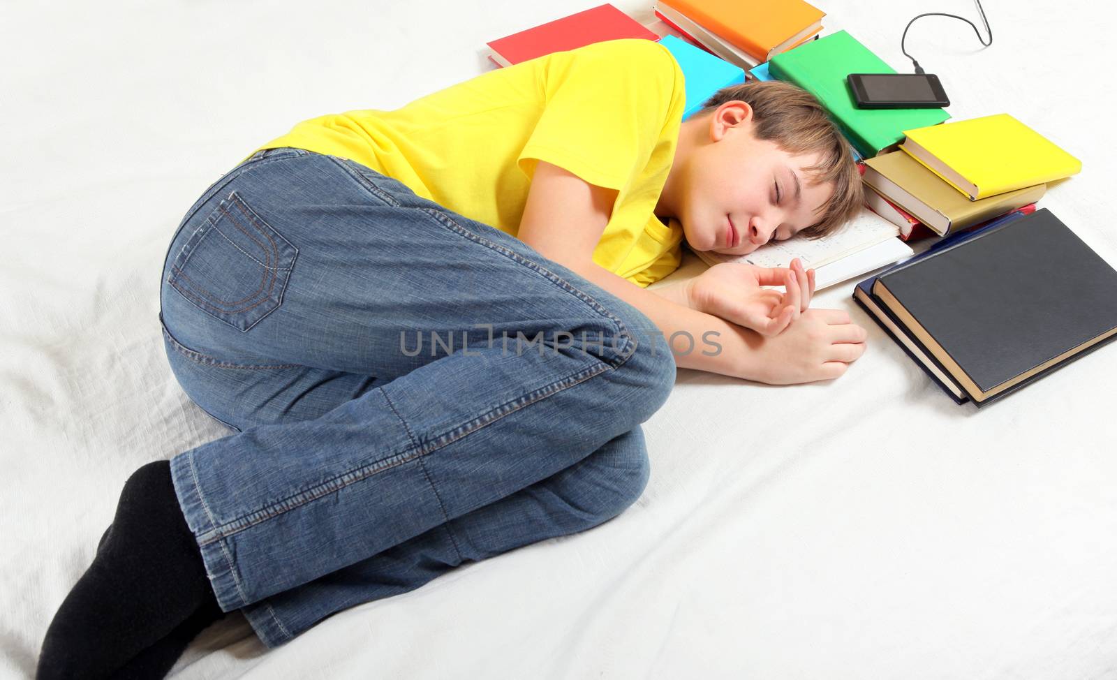 Tired Kid sleep with the Books on the Bed