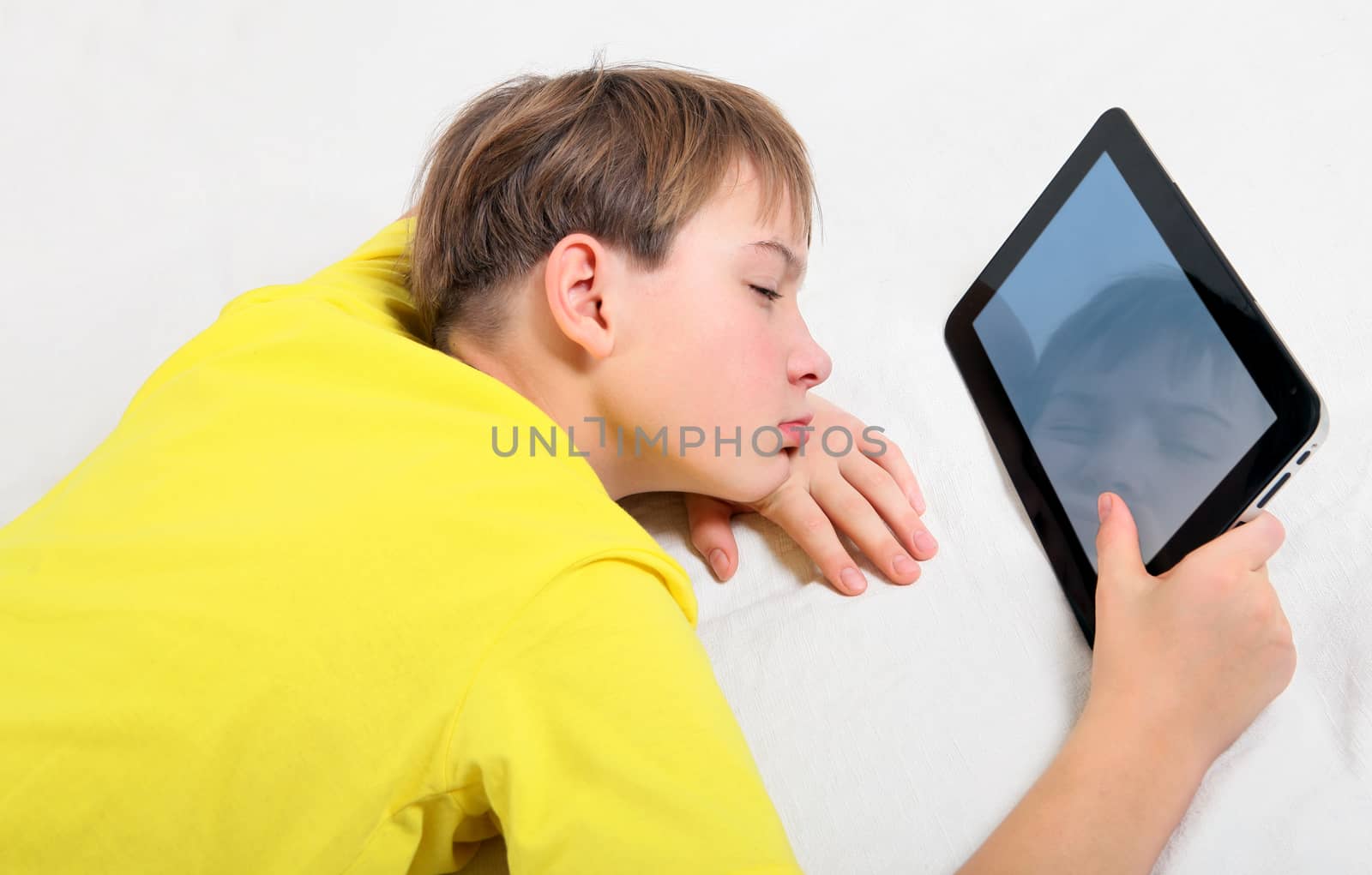 Tired Kid with Tablet Computer on the Bed