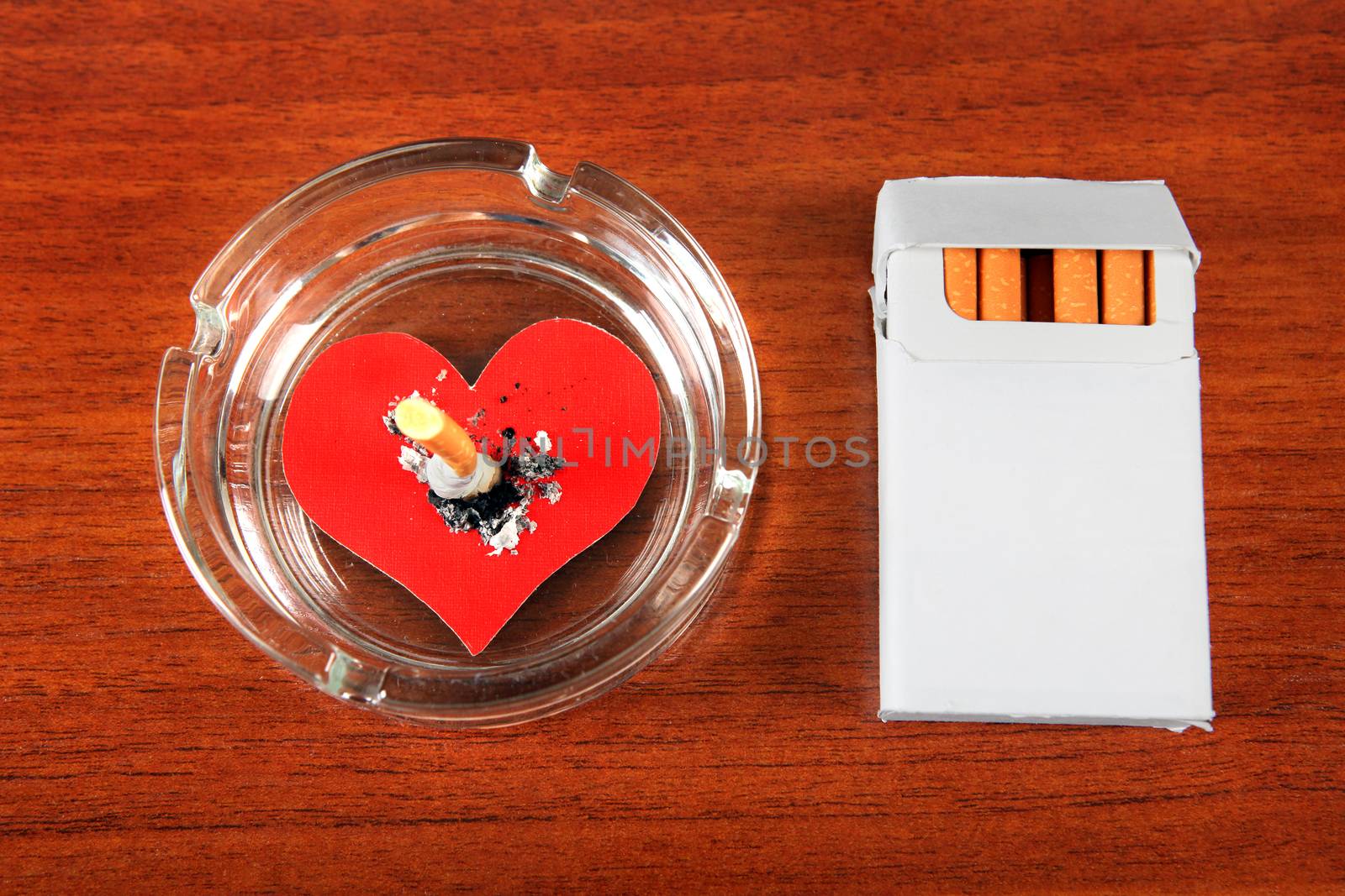 Cigarette in Ashtray with Heart Shape on the Table