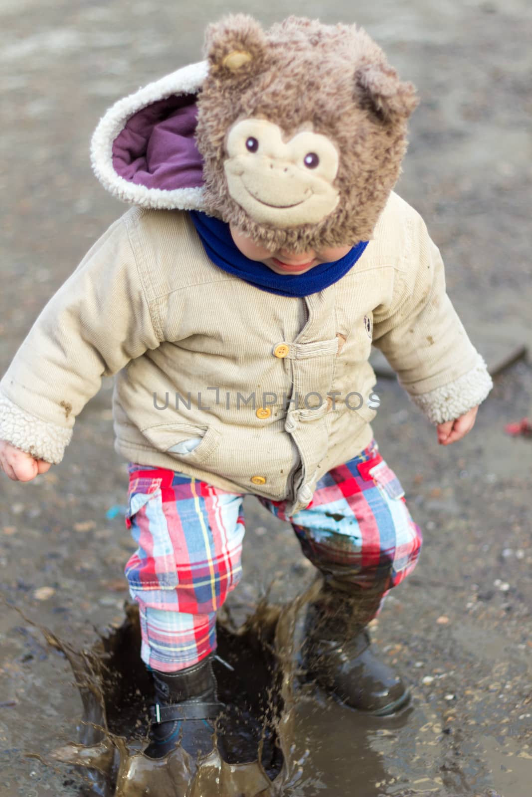 Kid playing in puddle on city street