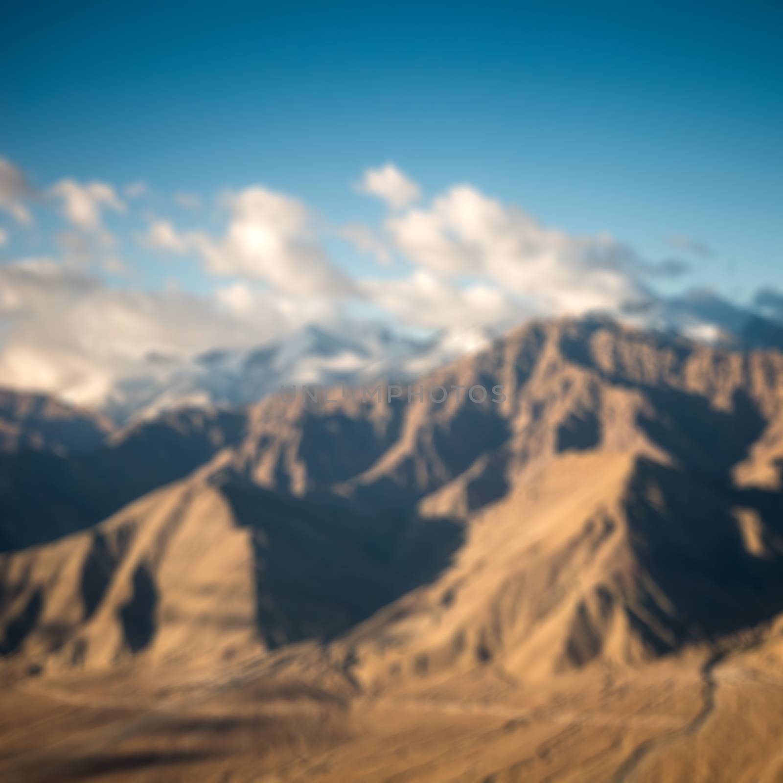 aerial view of clouds and mountain from airplane blurred background