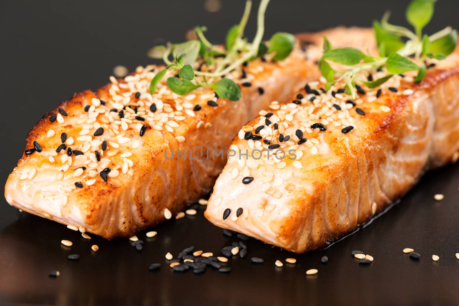 Grilled salmon on black plate by Nanisimova