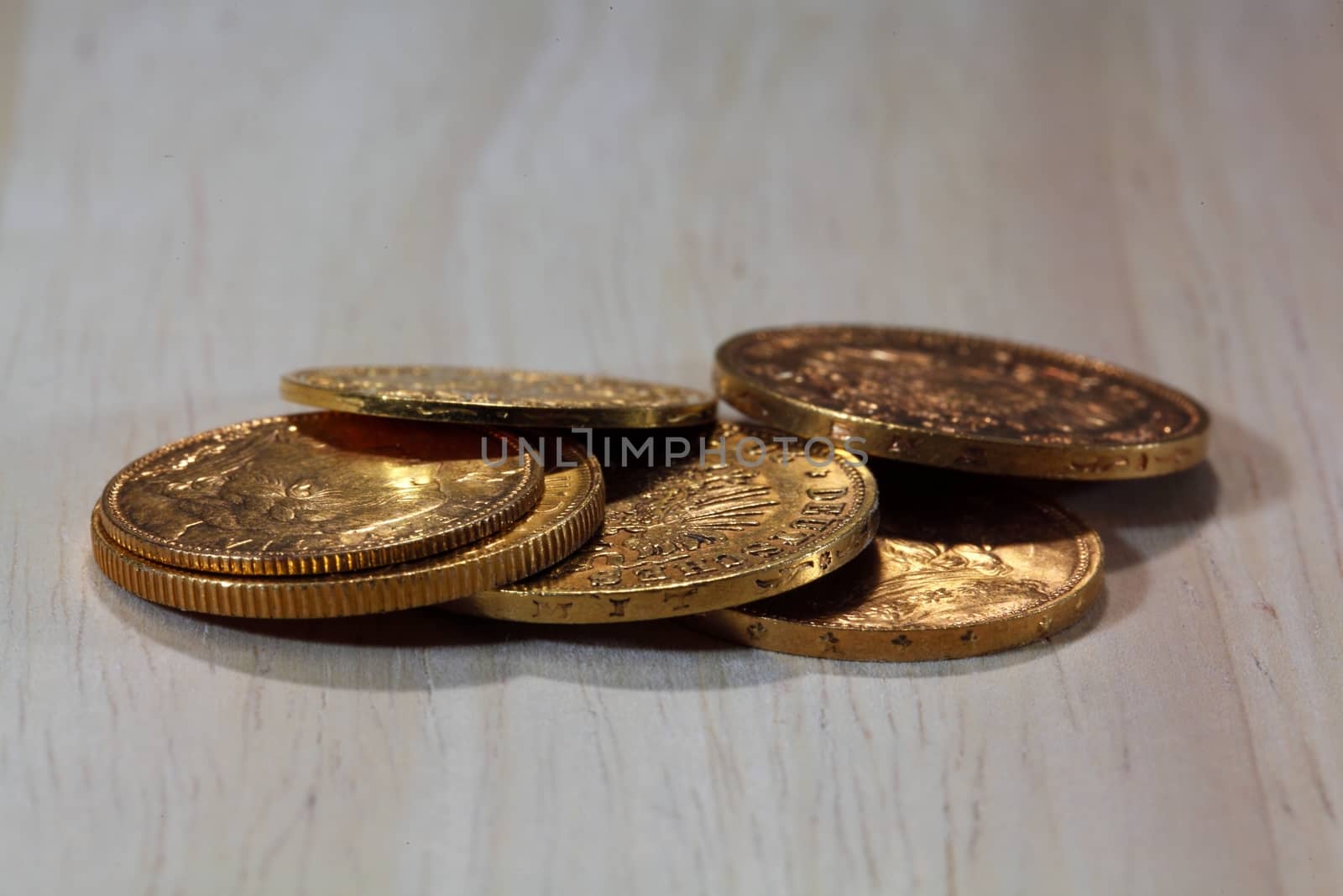 Old gold coins on a wood background