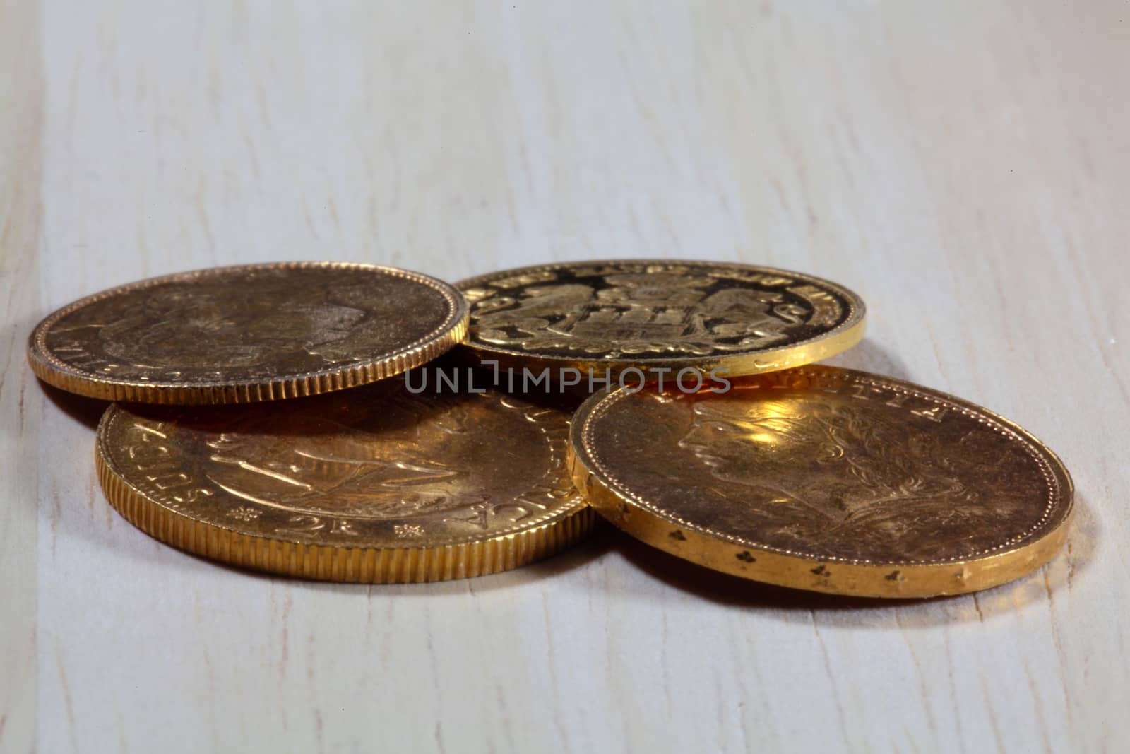 Old gold coins on a wood background. 