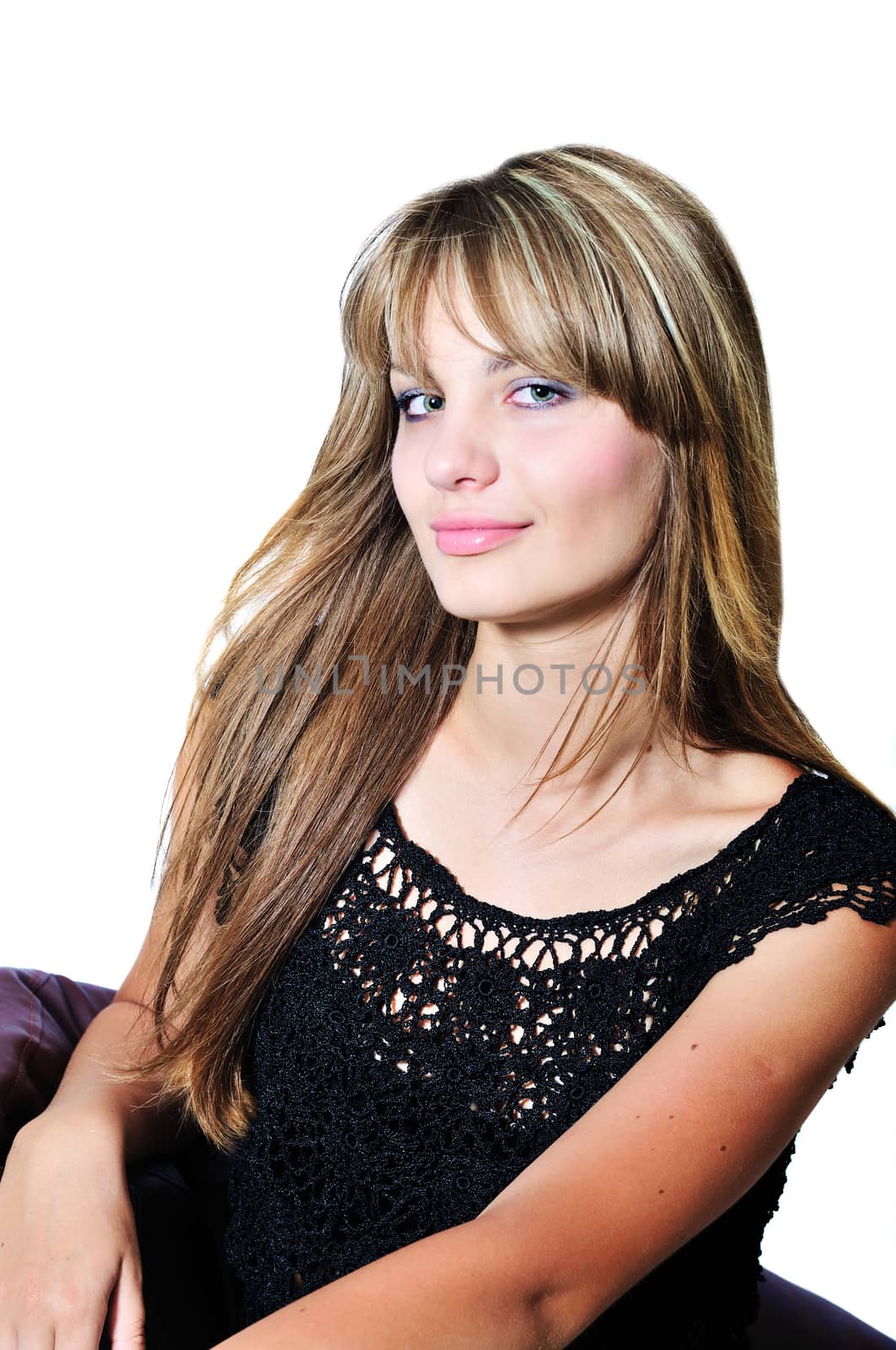 attractive girl sitting on the leather arm-chair in studio