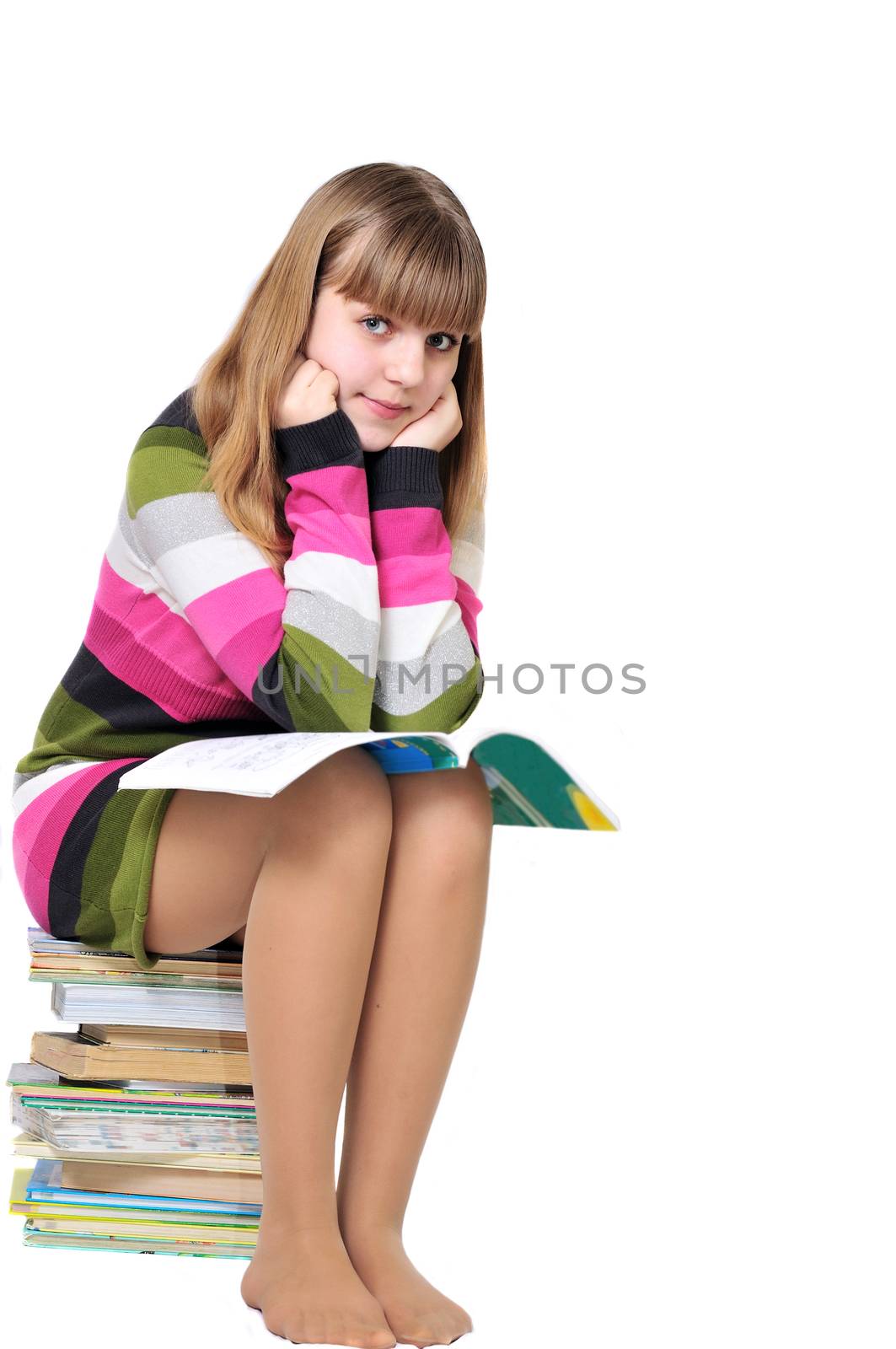 teen girl sitting on the pile of books  and doing homework