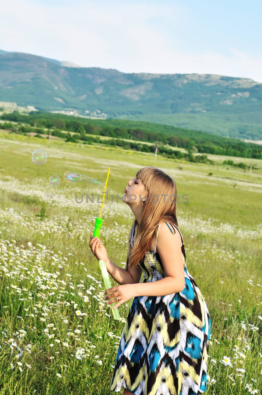 teen pretty girl blowing soap bubbles outdoors 