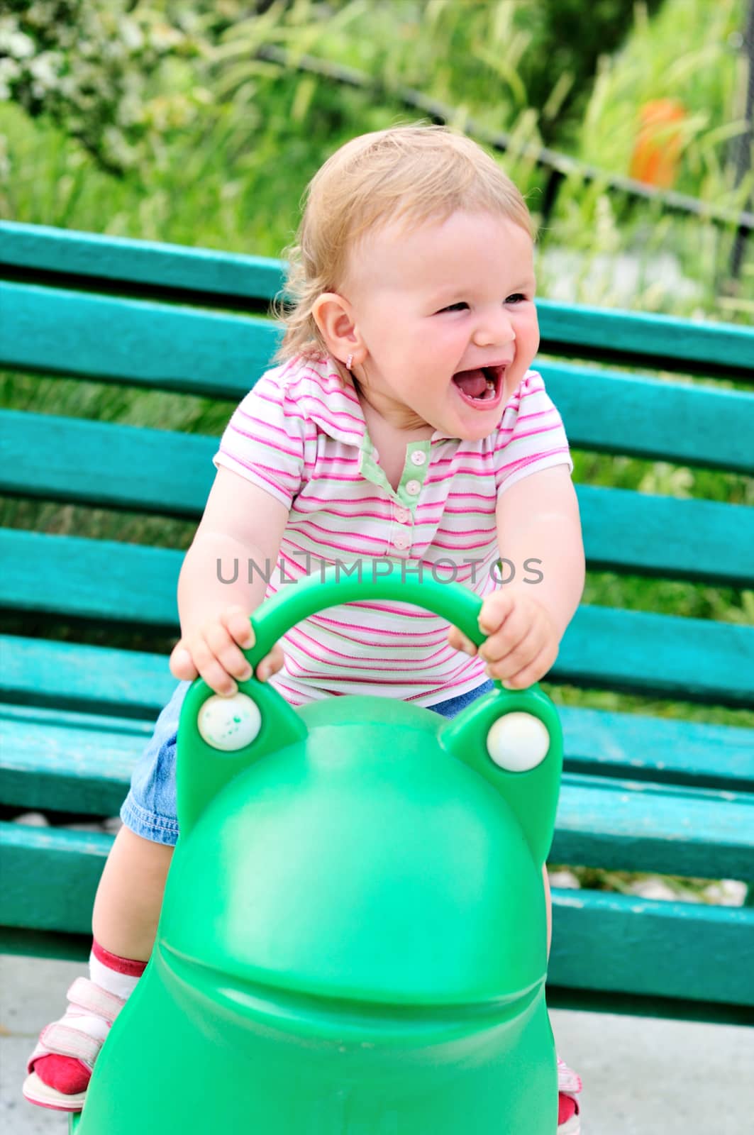 Small funny girl girl on spring frog swing