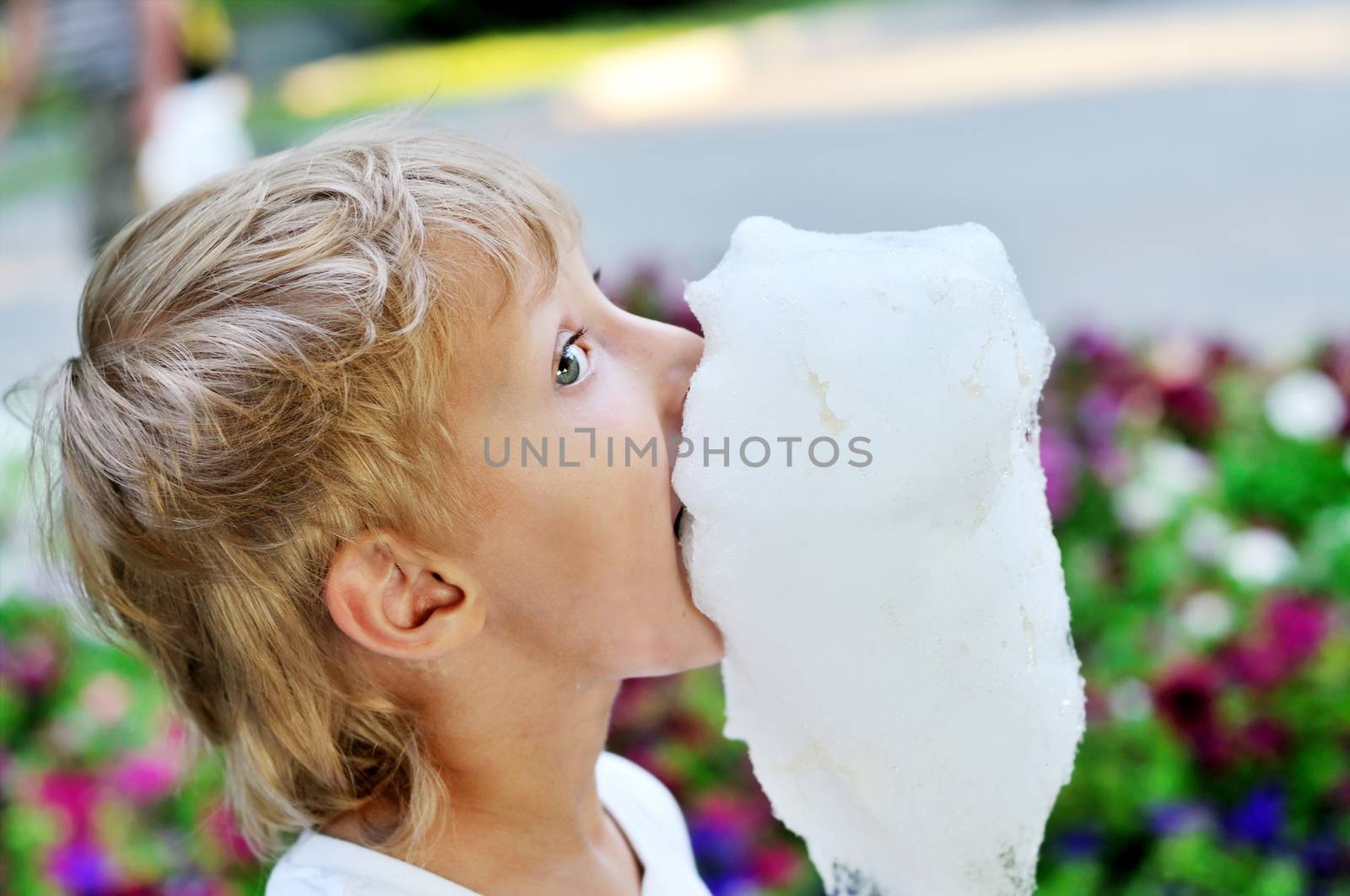 funny dirty face of little boy eating sweet cotton candy