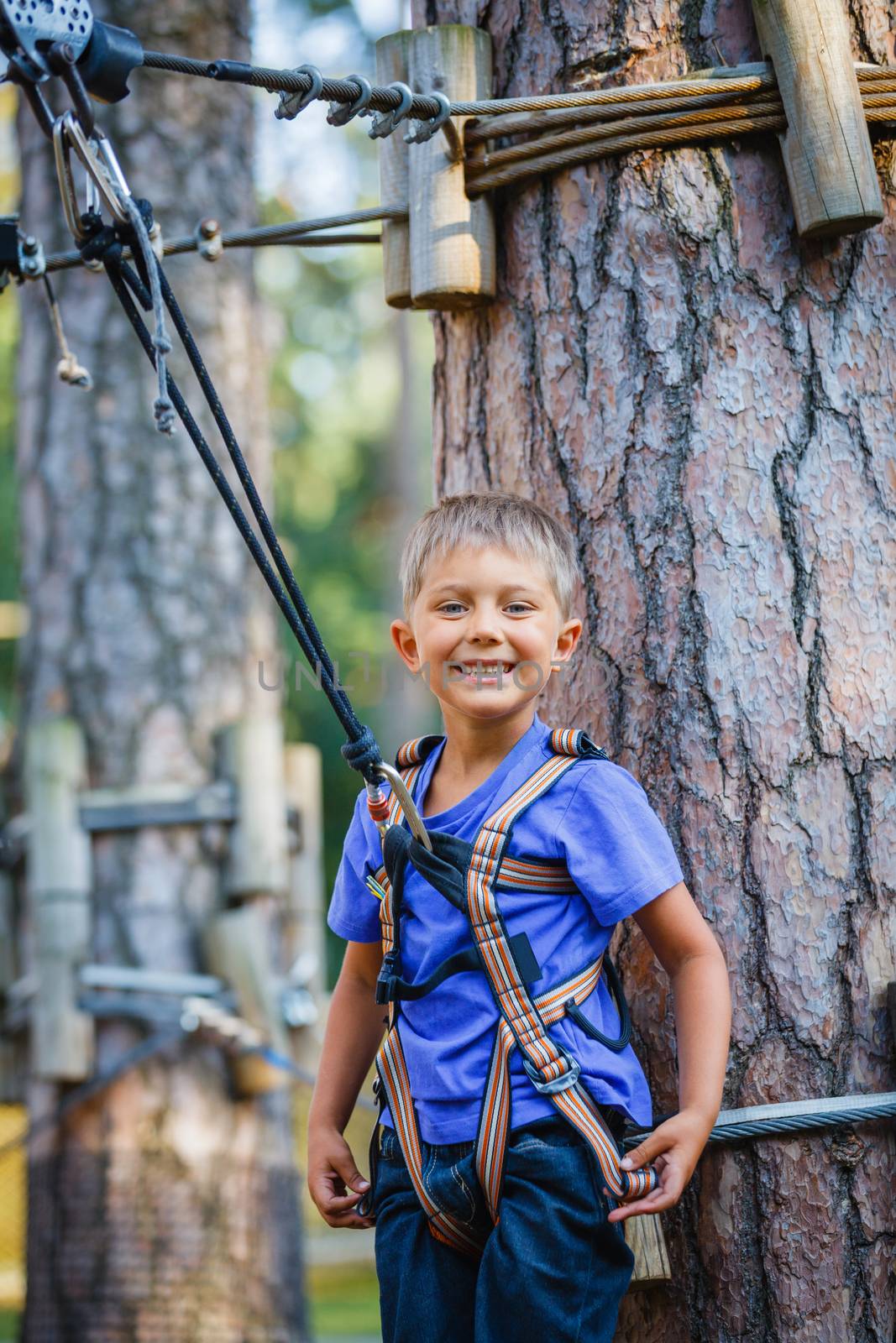 Boy in a climbing adventure park by maxoliki