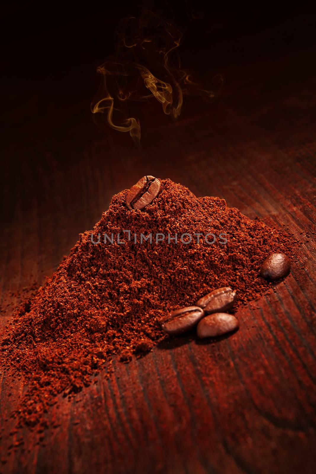 Fresh roasted coffee beans. Coffee beans and ground coffee with fresh aroma on brown wooden background with copy space. Culinary coffee drinking. 