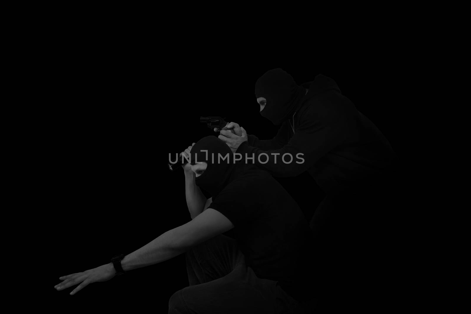 Two masked man with gun and flashlight isolated on black background. Dangerous criminal committing crime.