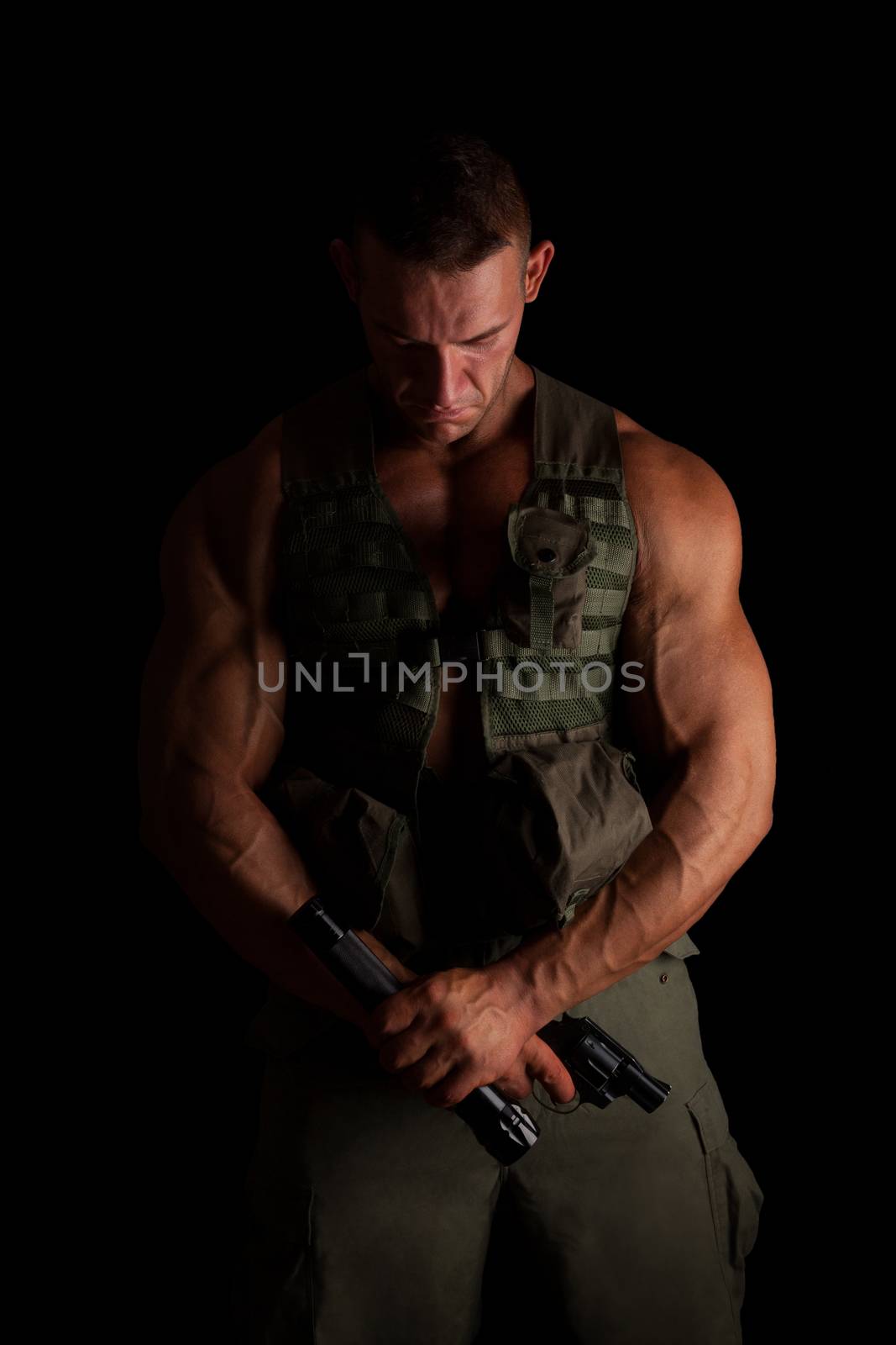 Soldier with gun and flashlight in green uniform standing proud isolated on black background. Army, security and protection.