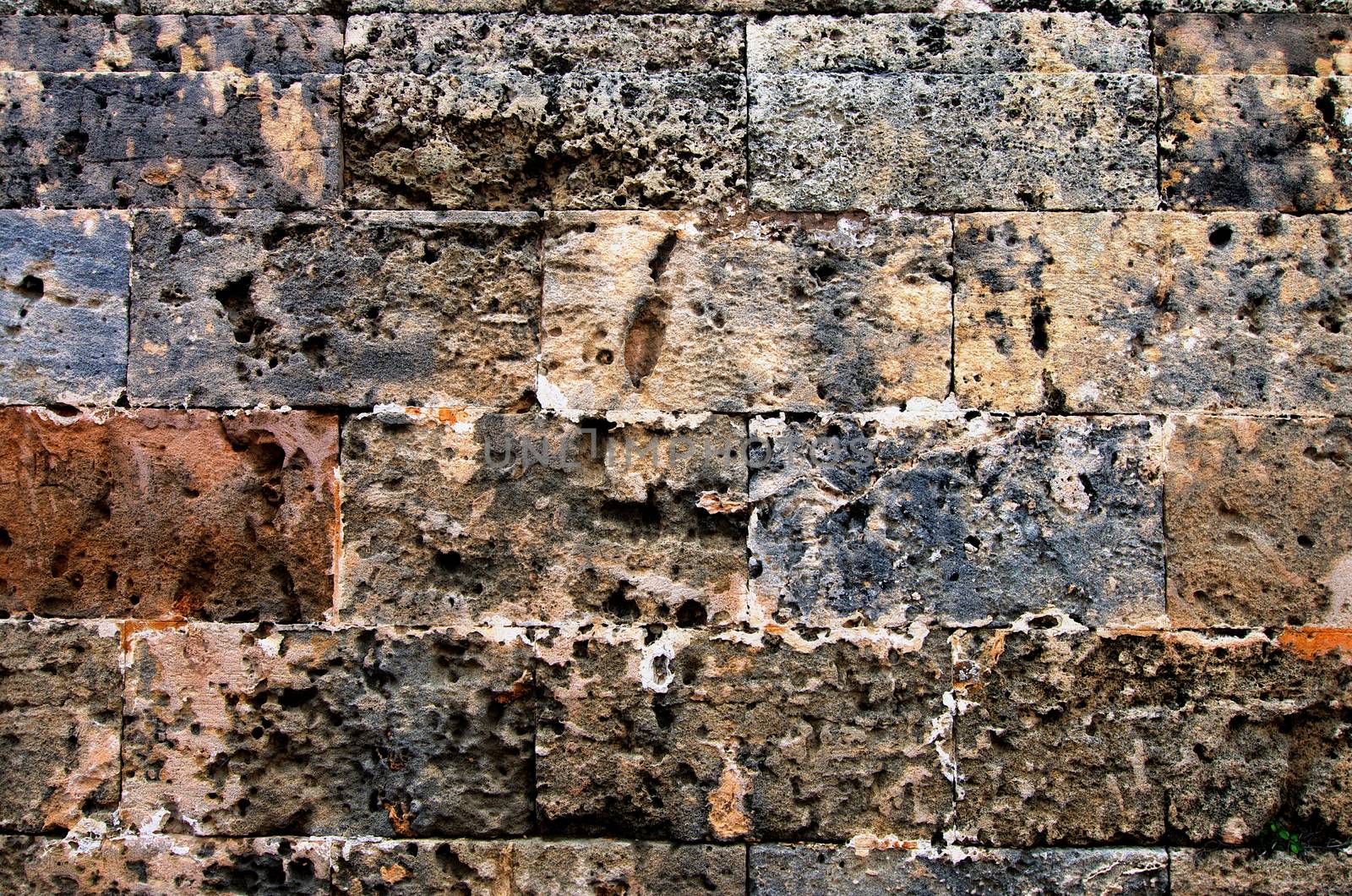 Multi-Colored Old Stone Block Wall Background closeup Outdoors