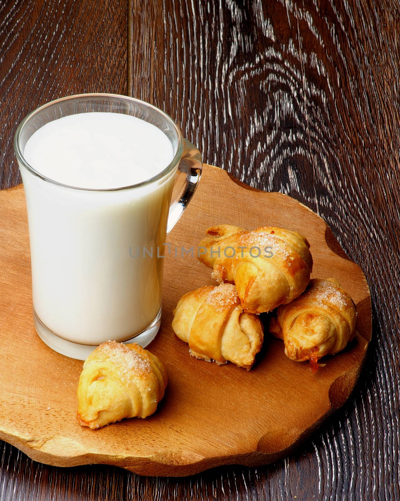 Homemade Croissant Cookies with Jam  and Glass Cup of Milk on Wooden Plate closeup on Rustic Wooden background