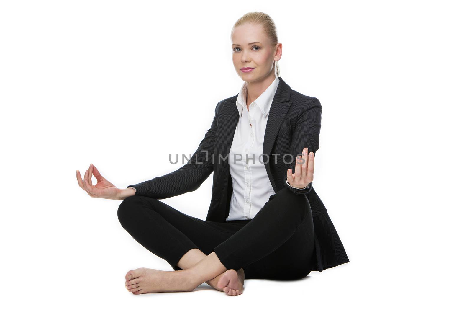 blonde businesswoman seated on the floor doing a yoga position