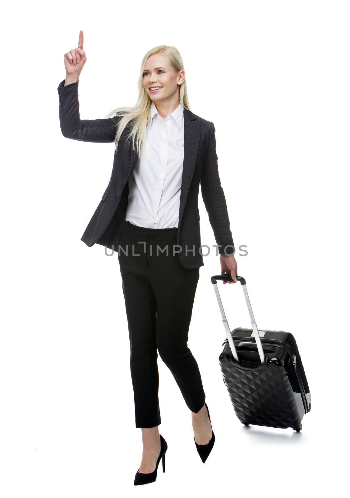 blonde businesswoman with suitcase smiling and stopping a taxi 