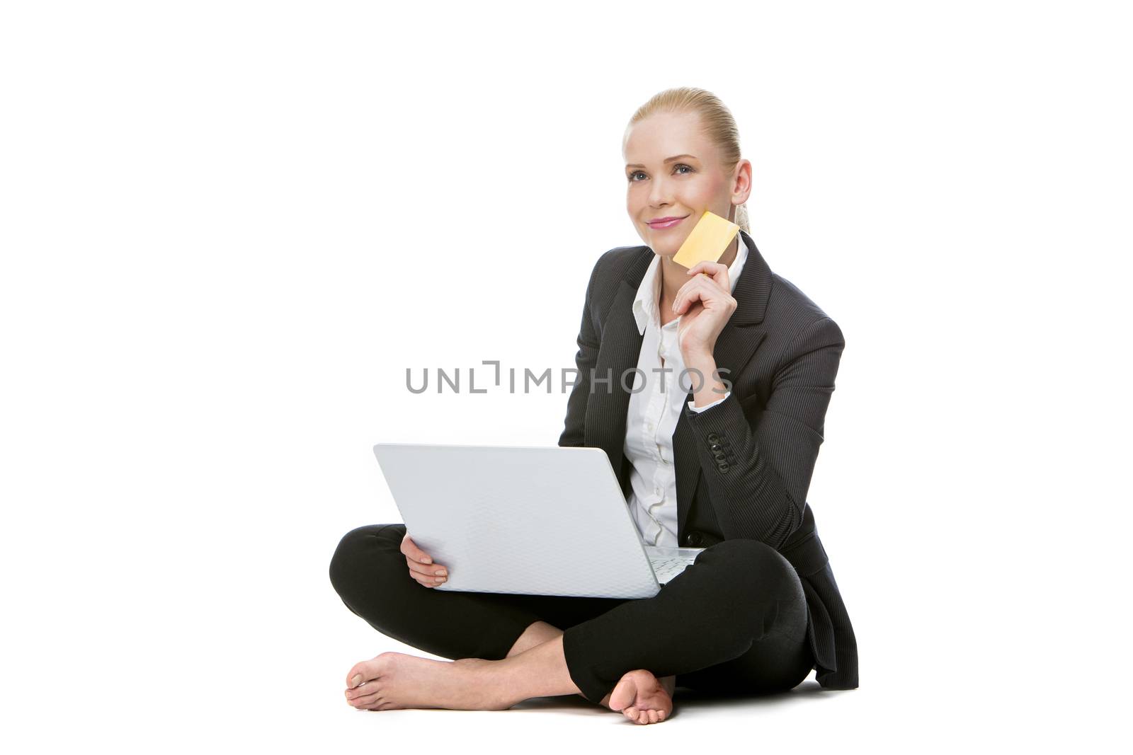 blonde businesswoman seated on the floor holding credit card and buying online