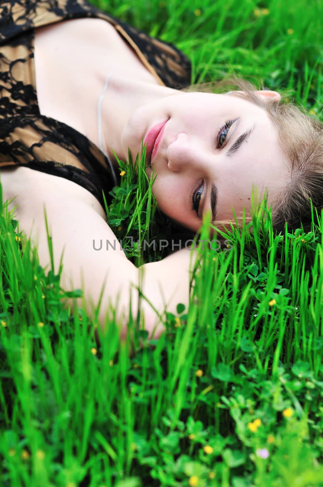 beautiful tender teen girl laying on the spring meadow 