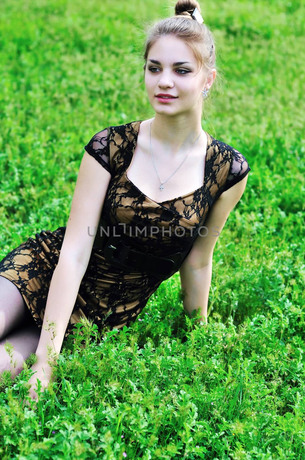 stunning beauty girl sitting in the high green grass 
