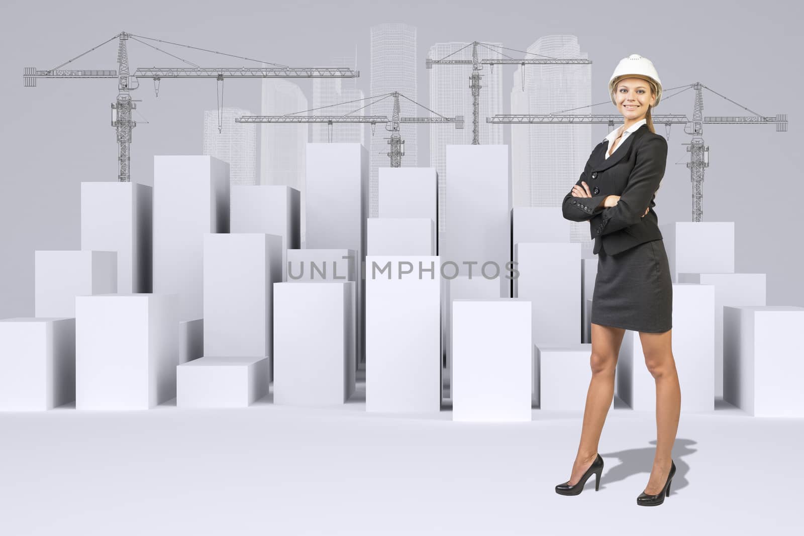 Business woman in suit and helment. Many white cubes with wire-frame buildings and tower cranes on gray background