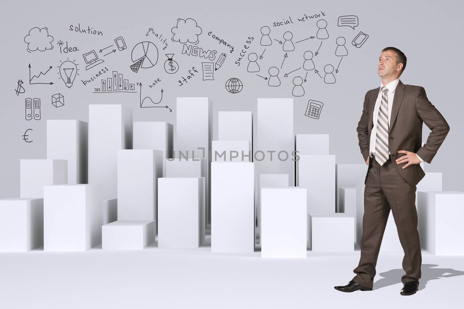 Businessman in suit standing akimbo. Many white cubes with business sketches on gray background