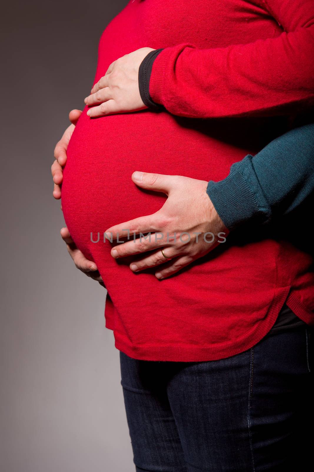 hands embrace a belly of the pregnant woman