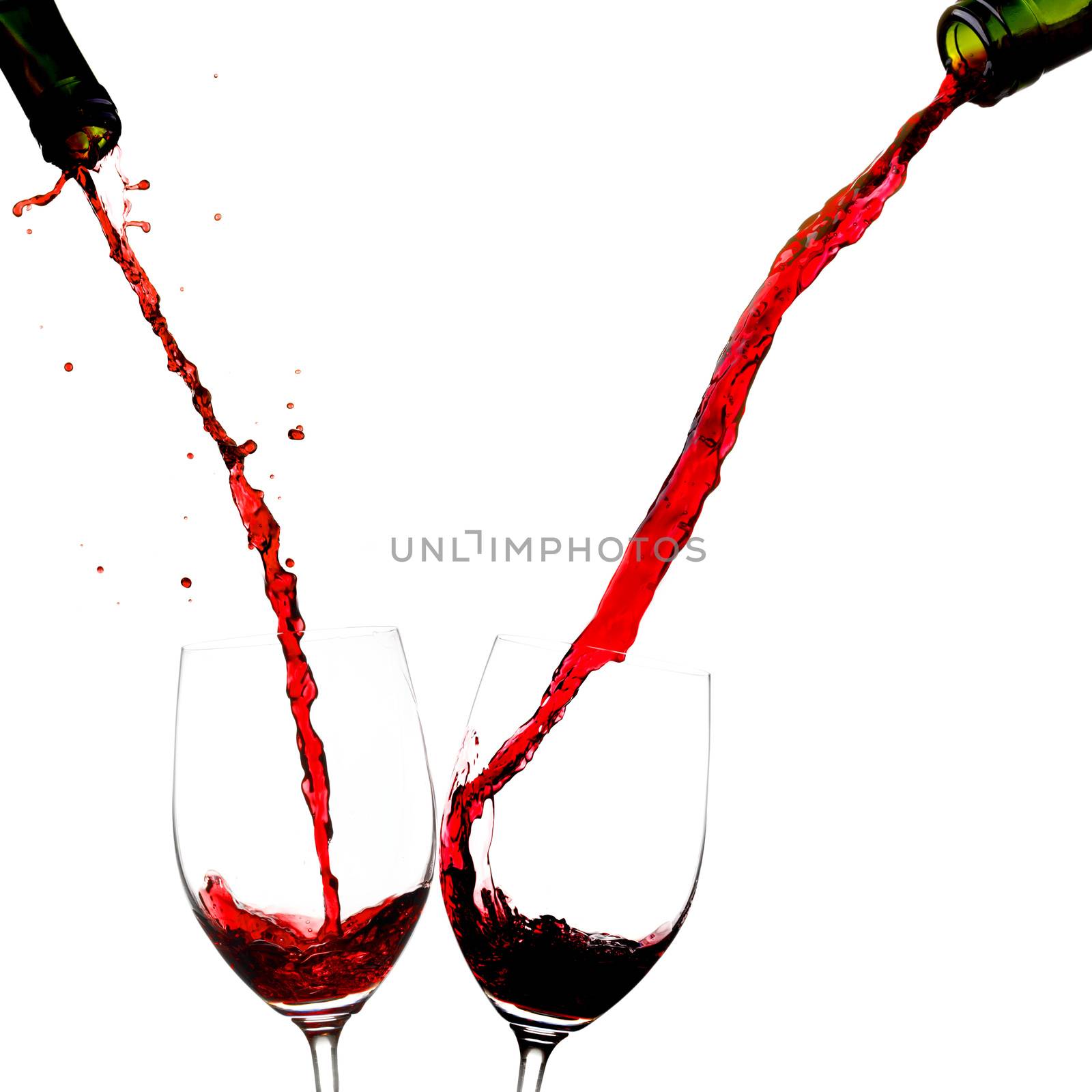 Pouring wine into two glasses isolated on white background