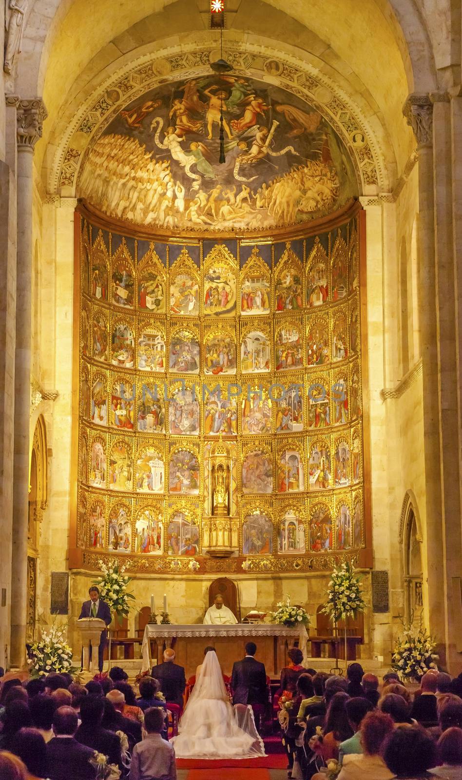 Marriage Groom Bride White Wedding Dress Ancient Apse House Old Salamanca Cathedral Castile Spain. 52 tablets completed in 1400s, 12 of which by Diego Delli, Italian artist, celebrating life of Jesus and Mary with fresco of final judgment above them.  Old Salamanca Cathedral next to the new Salamanca Cathedral is known as Catedral Vieja de Santa Maria.  Founded by Bishop Jerome of Perigold in the 1100s.  It was finished in the 1300s and dedicated to Saint Mary of the See 