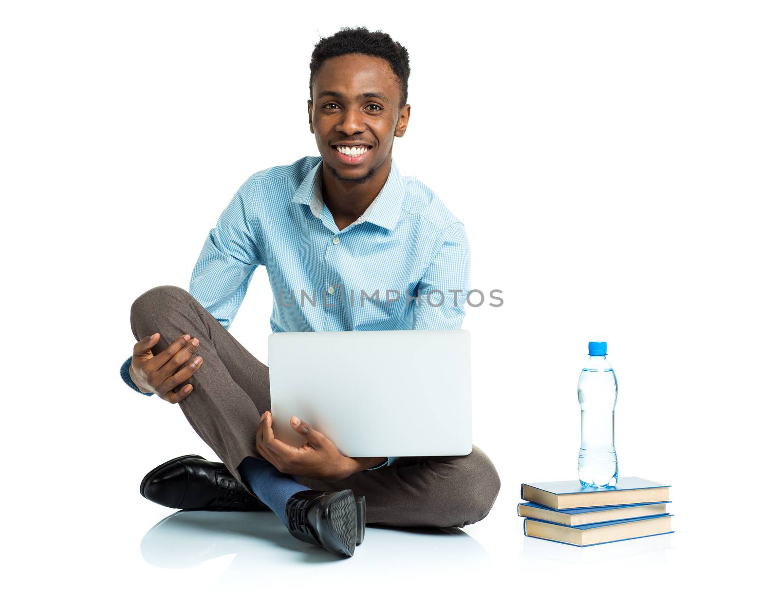 Happy african american college student sitting with laptop on wh by vlad_star