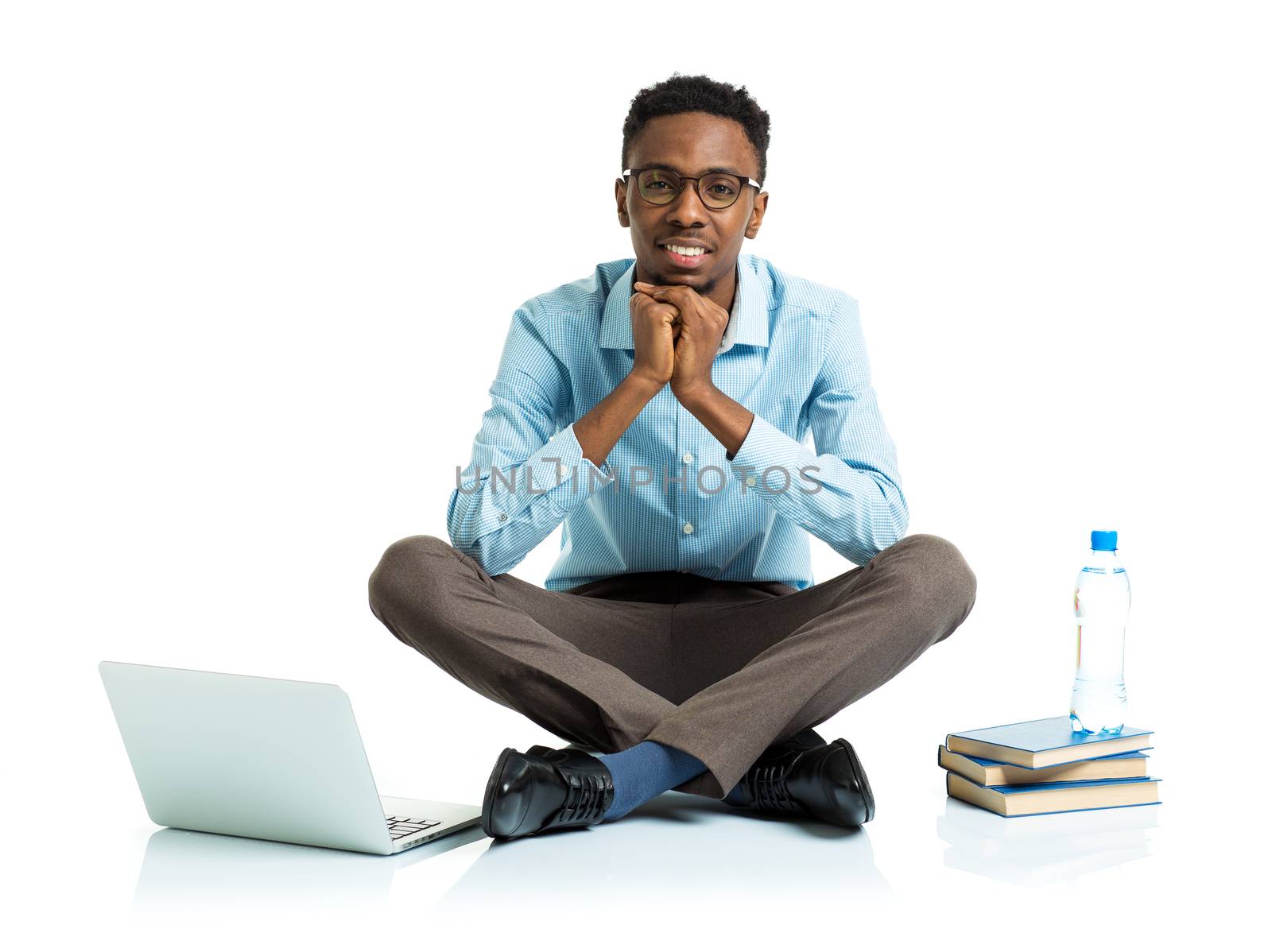 Happy african american college student with laptop, books and bottle of water sitting on white background