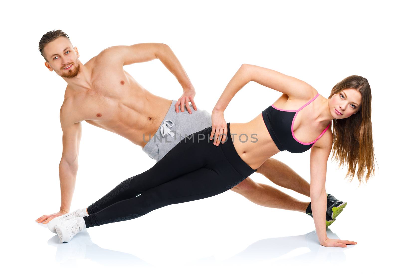 Attractive sport couple - man and woman doing fitness exercises on the white background
