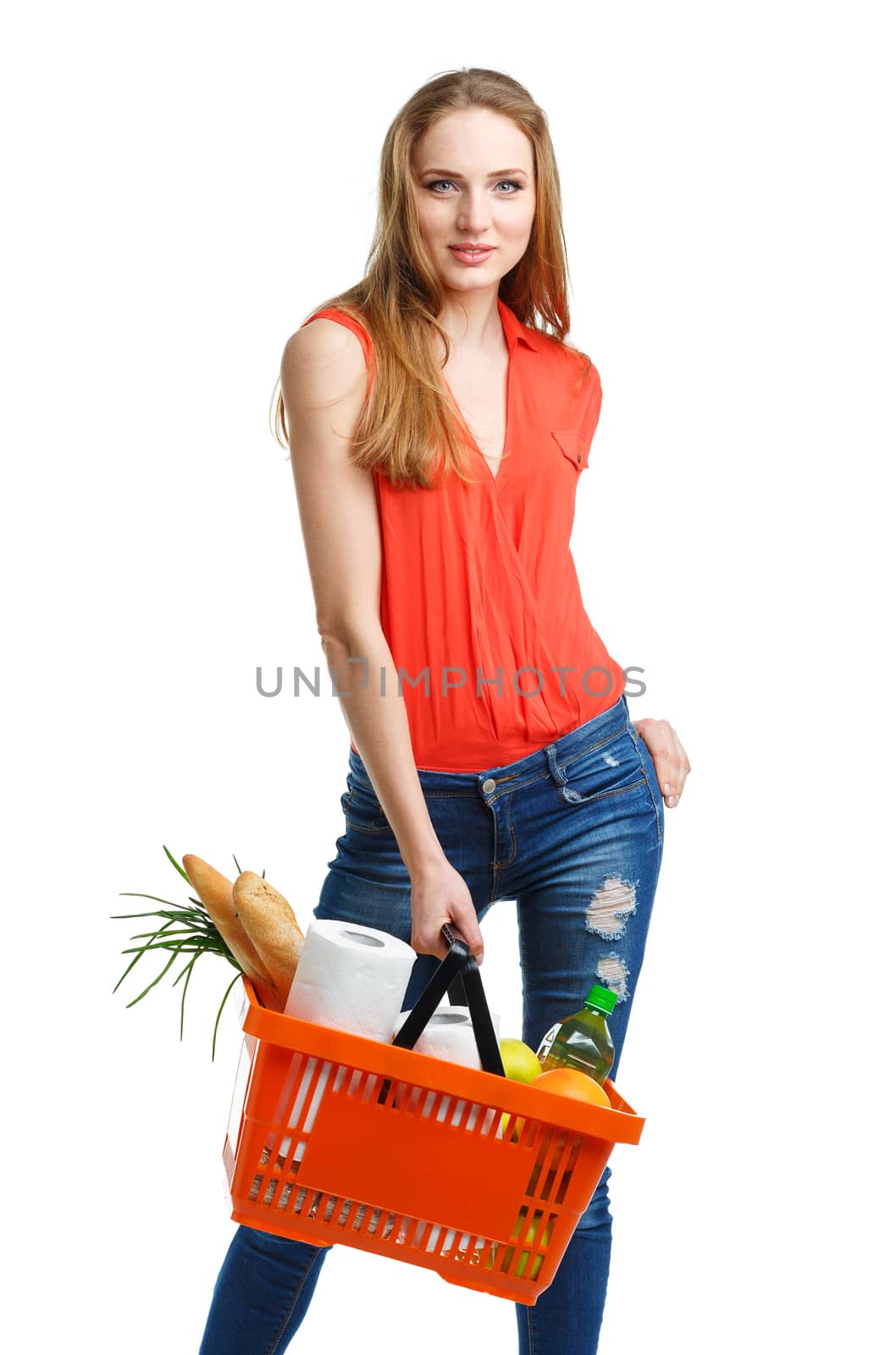 Happy young woman holding a basket full of healthy food. Shopping