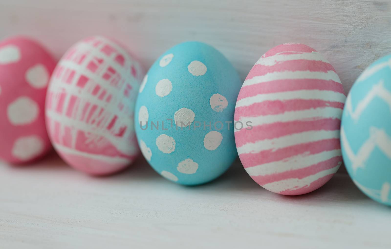 Pink and blue easter eggs on a wooden background