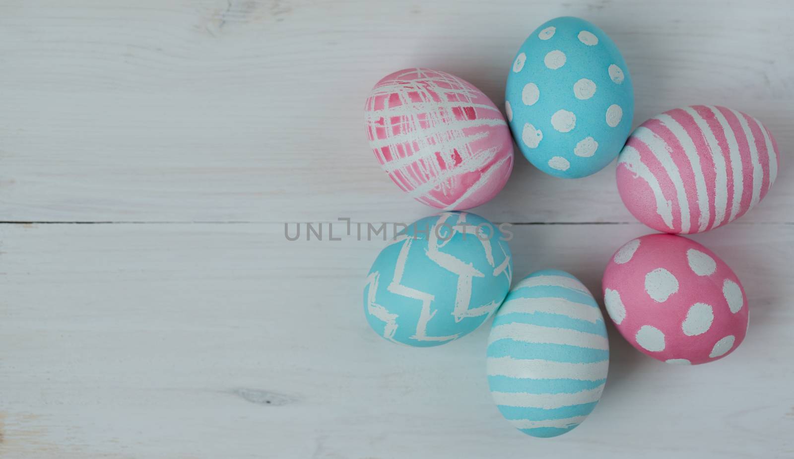 Pink and blue easter eggs on a wooden background