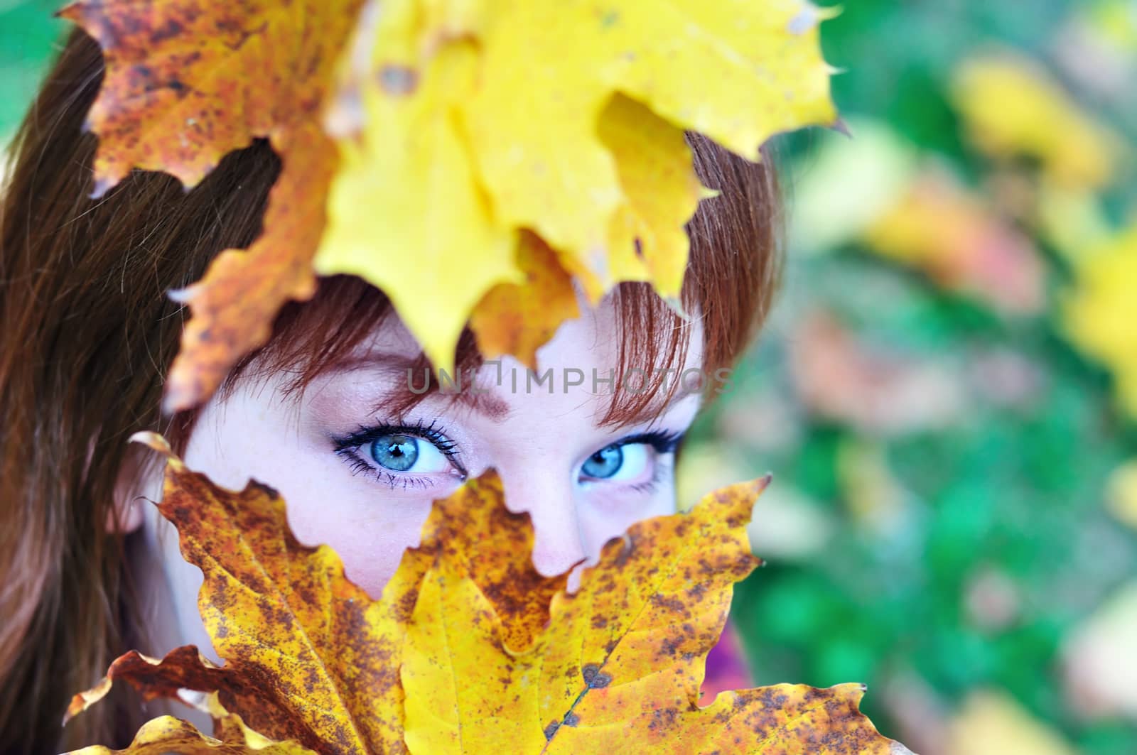 autumn view of redheaded girl in forest
