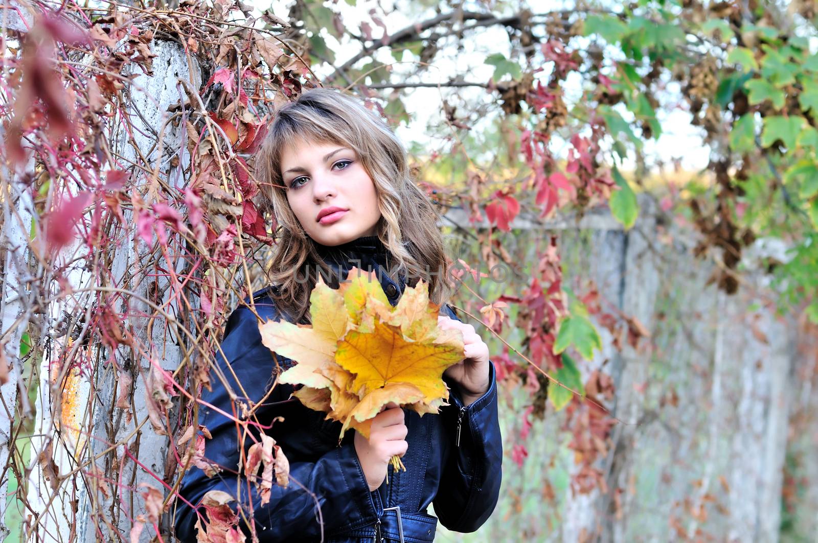 autumn pensive teen girl with foliage in hands