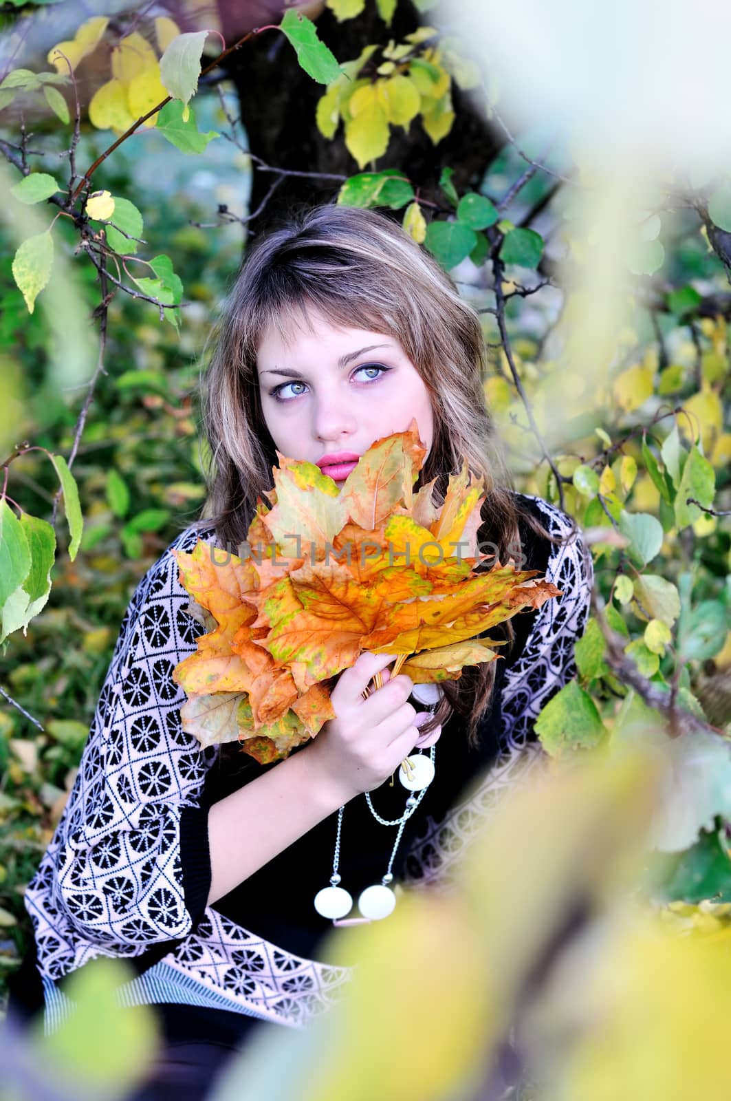 teen girl in forest holding foliage in autumn time