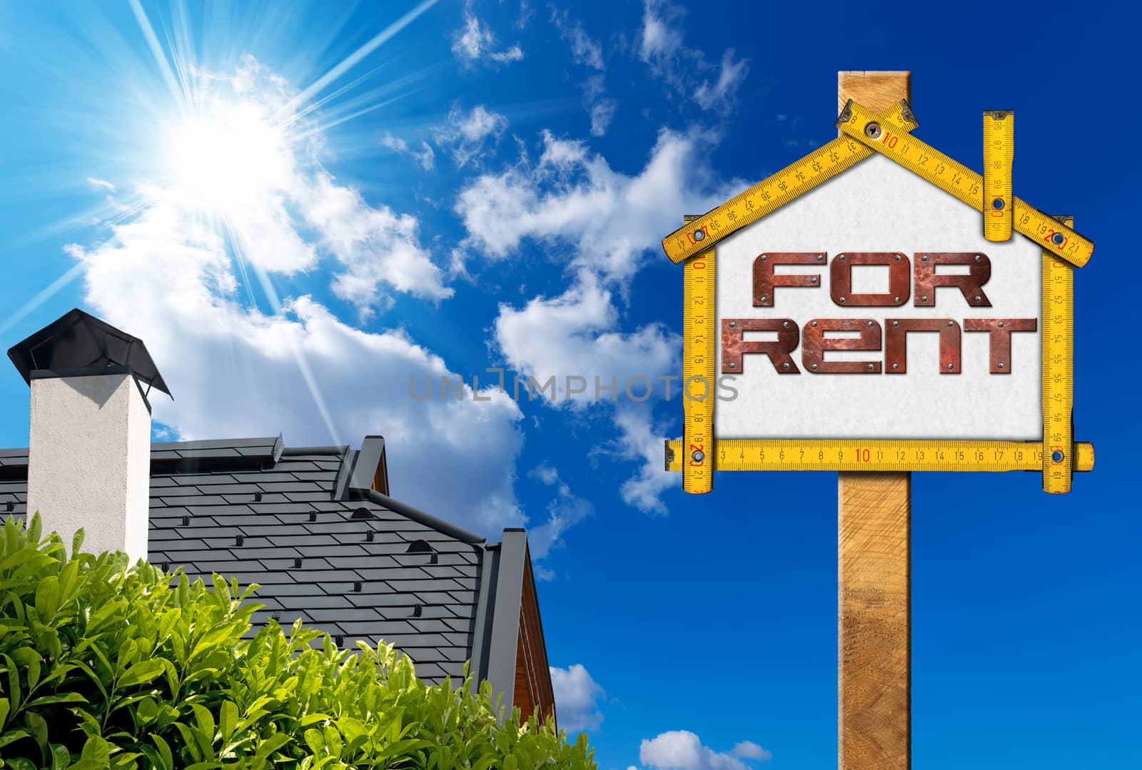 Yellow wooden meter ruler in the shape of house with text for rent. For rent real estate sign on blue sky with roof, clouds and sun rays