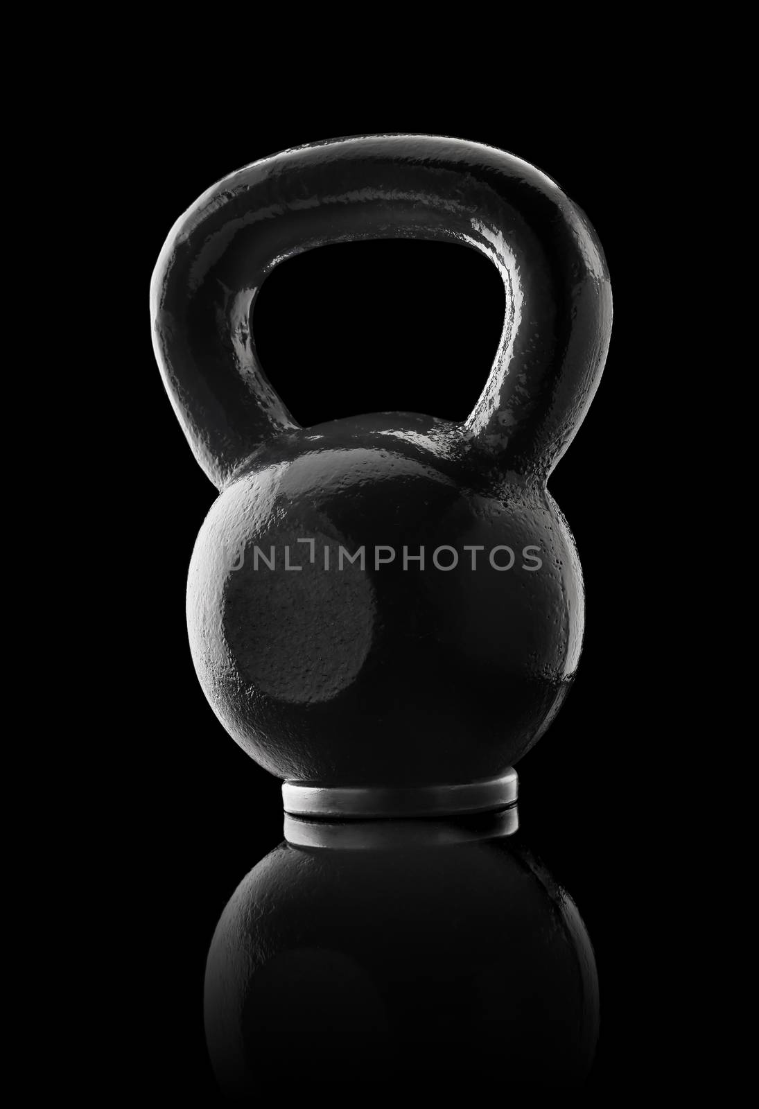Black metallic kettlebell on black reflective background.