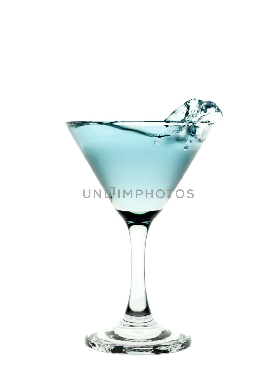 Green liquid splashing in a martini glass isolated on white background