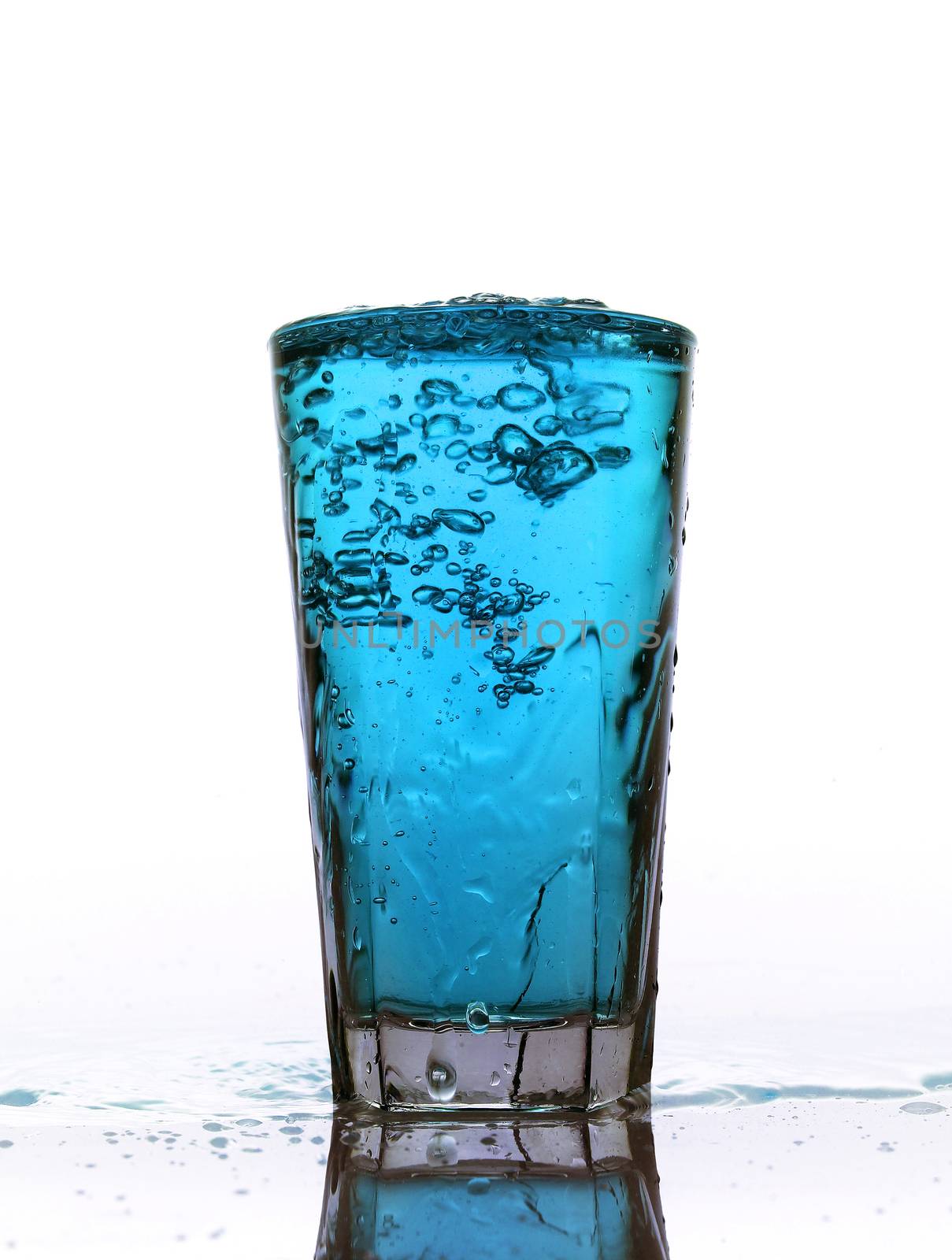 Glass of splashing Blue lemonade isolated on white background