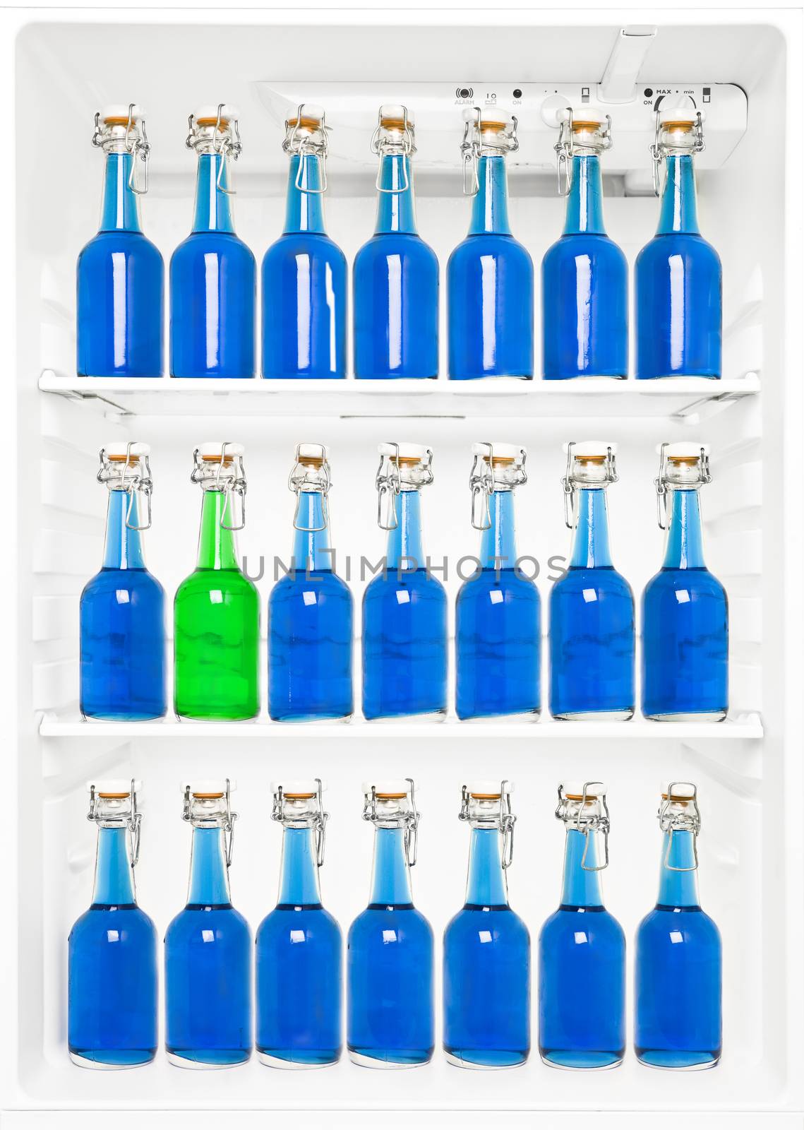 One green Bottle among a large group of blue bottles in a fridge